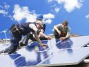 three people install home solar panels