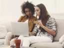 two women shopping on a laptop