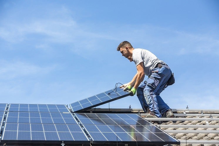 two men install a solar panel system