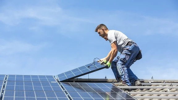 man installs a solar panel system