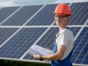 man stands in front of solar panels