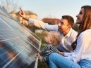 man, woman and child look at solar panels