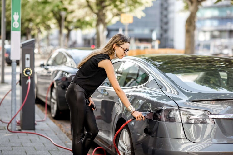 a person charges their car on the street