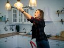 person installs light bulb in their kitchen