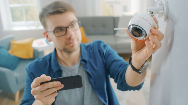 man adjusting his security camera