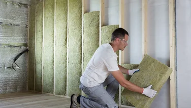 Man adding insulation to house