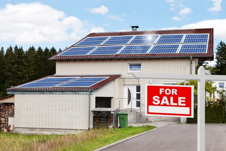 solar panels on a home with a for sale sign