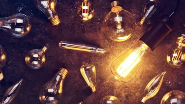 light bulbs lying on the ground. one is switched on