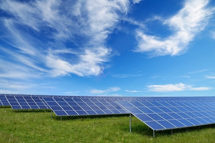 Solar panels in a field with blue sky