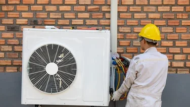 Someone performing heat pump installation outside