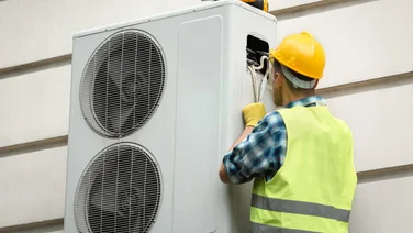 man installing a heat pump