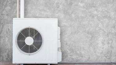 Heat pump against grey wall