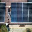 People installing solar panels on a roof