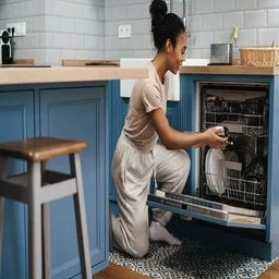 Person loading the dishwasher at home