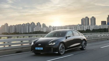 a hyundai ioniq 6 on a road against a skyline and a sunrise