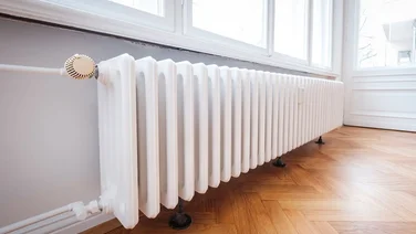 long white radiator on hardwood floor