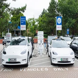 two white cars charging up at a tesco electric vehicle charging station