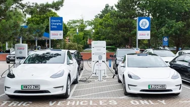 two white cars charging up at a tesco electric vehicle charging station