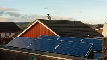 Pitched solar panels on a flat roof on a property in the UK, at sunrise