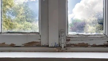 old rotting white wooden windows picture from inside of a house