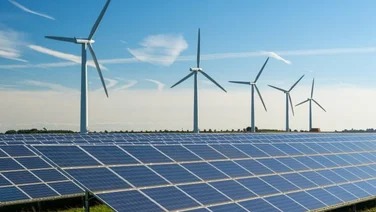 wind turbines and solar panels against a blue sky