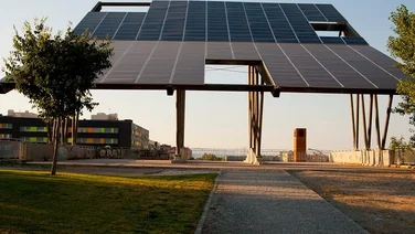 solar panel pergola in parking lot with office buildings in background