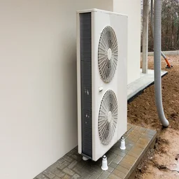 heat pump outside home with white wall, and ground being excavated