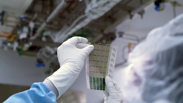 an MIT scientist holding up a printed solar cell