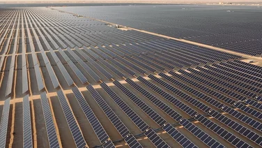 rows of solar panels in a large solar farm in the desert