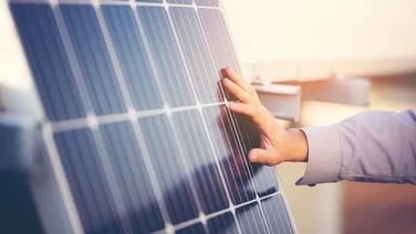 Close up of engineer's hand touching a solar panel