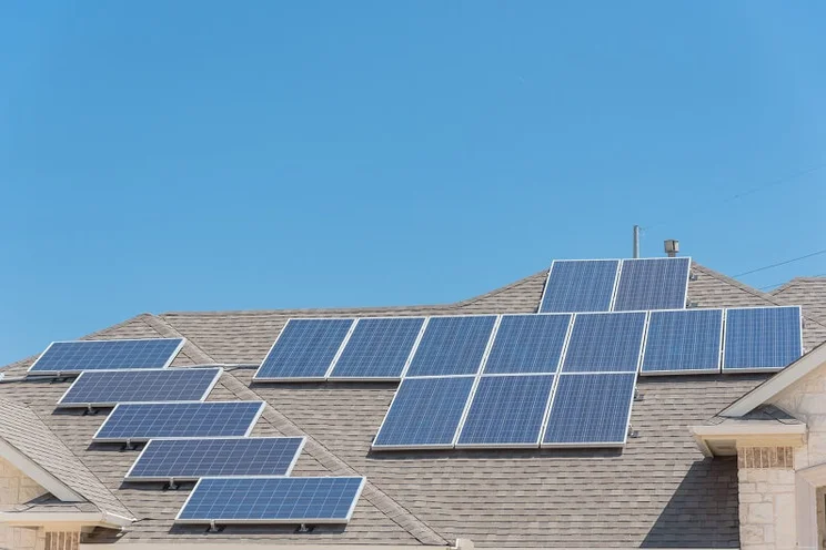 Solar panels on a roof in Texas, USA, with a clear blue sky as the background