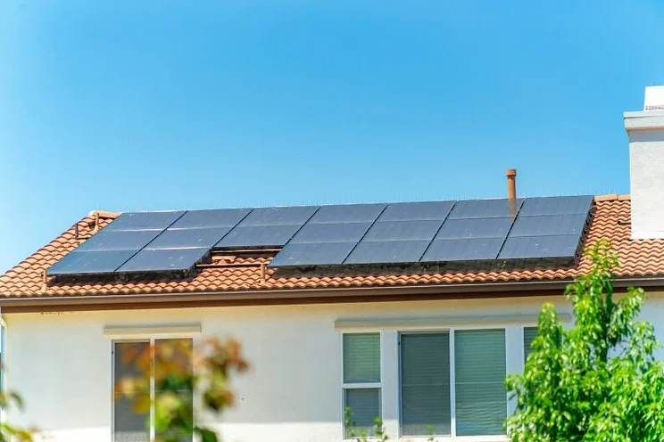 Home with solar panel system, bright blue sky