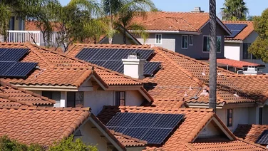 Solar panels on properties in California, with a clear blue sky in the background