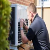 An air-source heat pump being installed by an engineer.